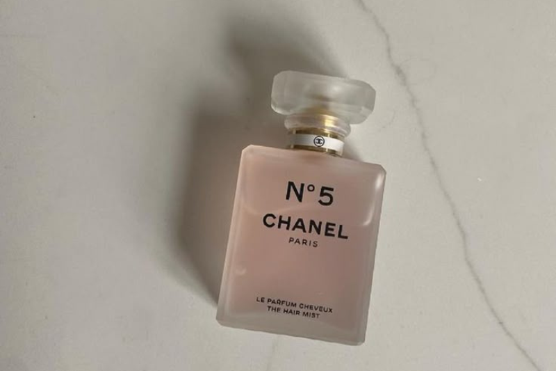 Frasco rosa do melhor perfume Chanel feminino, Chanel Nº 5, sobre superfície clara.