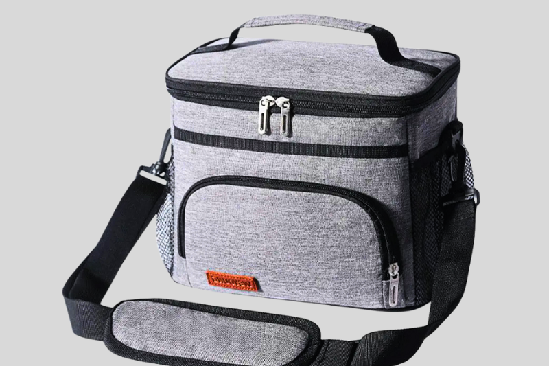 Bolsa térmica cinza com múltiplos bolsos e alça lateral, vista frontal.