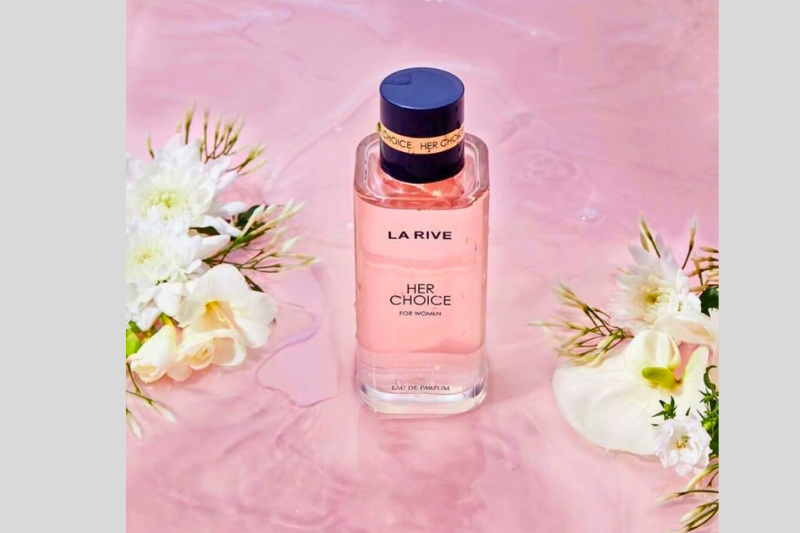 Perfume HER com caixa rosa e flores brancas ao redor.