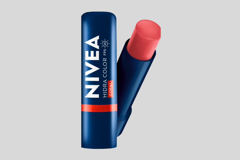 Hidratante labial NIVEA em embalagem azul com tampa aberta mostrando o produto rosado.
