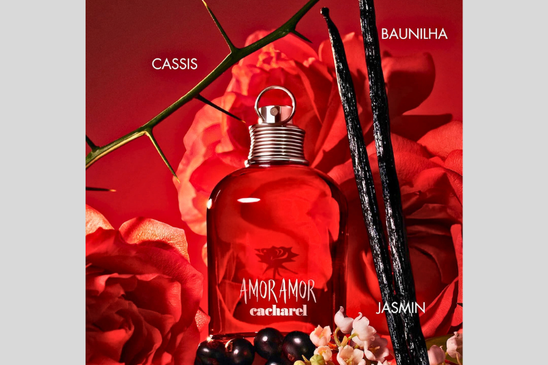 Caixa e frasco do perfume Amor Amor da Cacharel lado a lado, em composição artística sobre fundo vermelho.