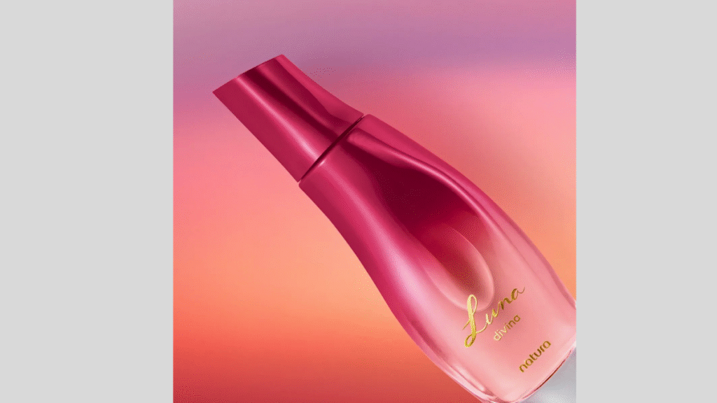 rasco de perfume rosa em destaque, exibido inclinado sobre fundo degradê em tons quentes e suaves.