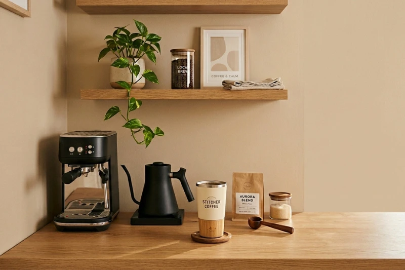 Cantinho do café moderno e acolhedor com chaleira elétrica e iluminação natural.