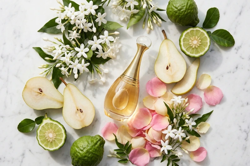 Flat lay de pêras frescas, bergamota, flores de jasmim e pétalas de rosa sobre mármore branco